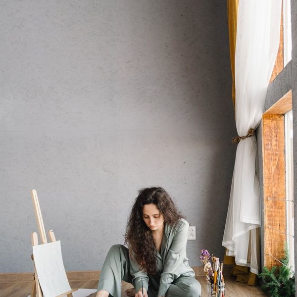 Woman meditating peacefully in a dimly lit studio.